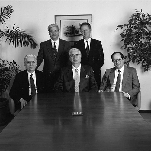 black and white photo of founders sitting at the end of a table