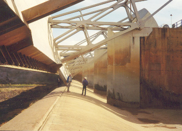 two men walking through dam structure