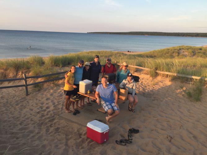 people sitting at a picnic table on sand