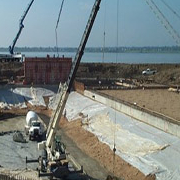 construction cranes on dam site by the water