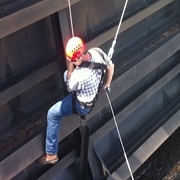 construction worker in hard hat being lowered beside wall