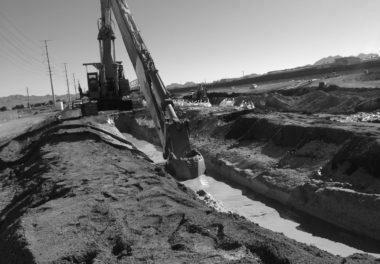 crane digging path for water in dirt