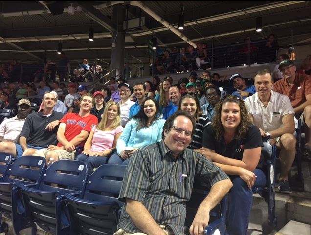 GEI employees sitting at a baseball game