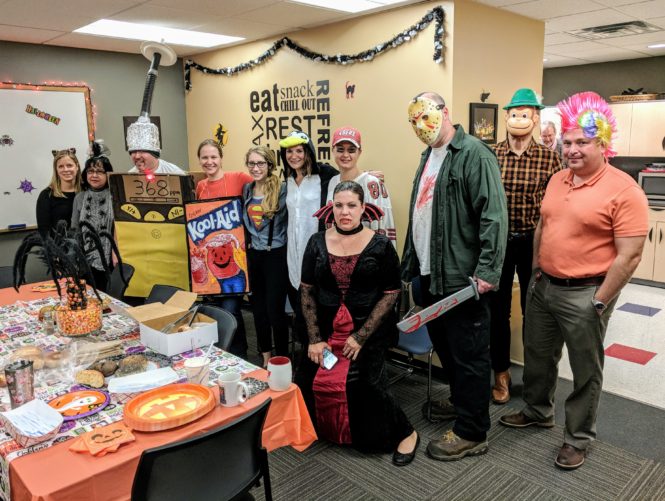 team in various costumes at Halloween party