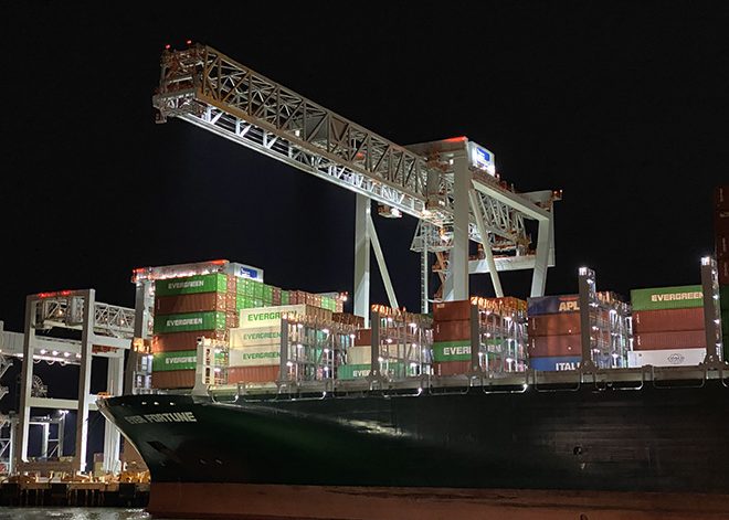 Container ship under crane in port