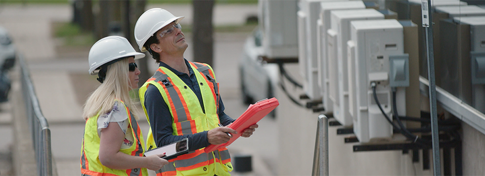 Workers in hardhats taking measurements