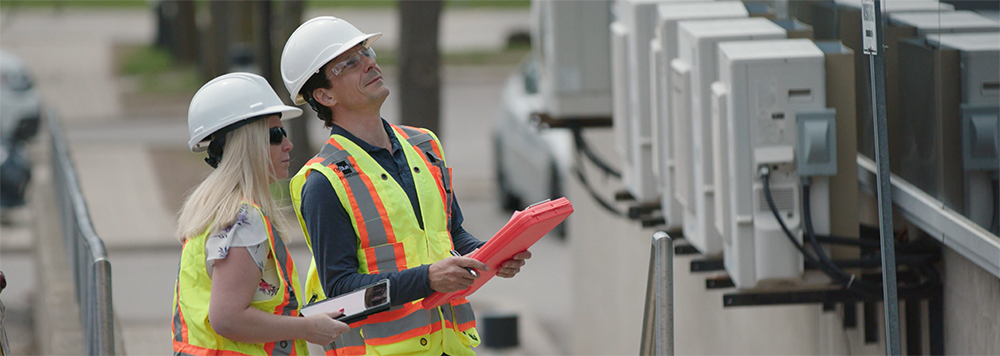 Workers in hardhats taking measurements