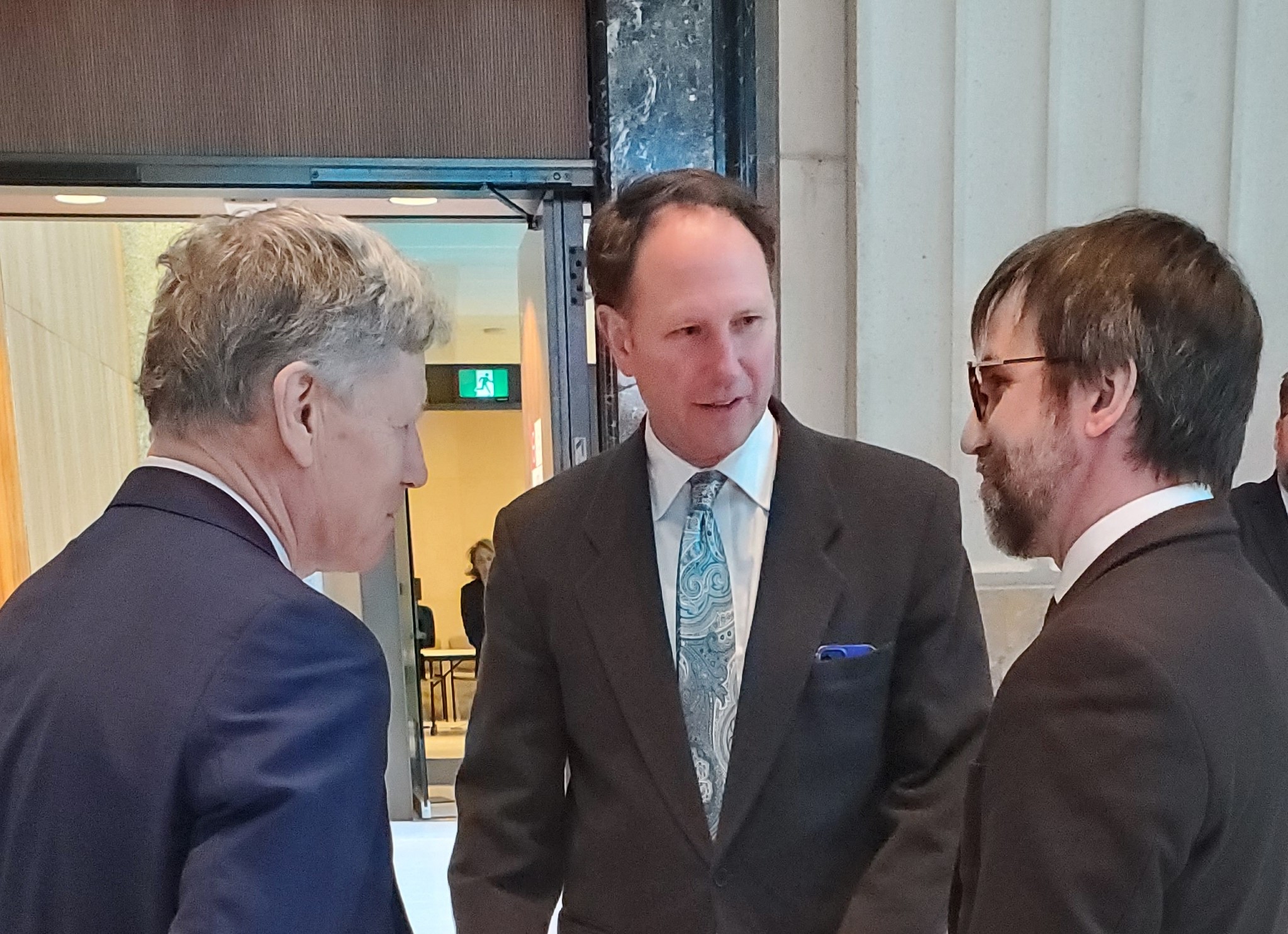 Men in suits having a discussion at a conference