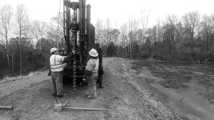 Workers adjusting drill rig