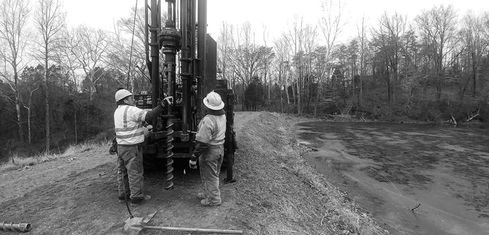 Workers adjusting drill rig