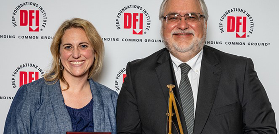 Man and woman holding awards