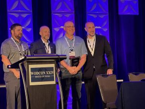 Men behind podium holding award