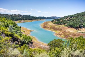 High angle view of Anderson Reservoir, a man made lake in Morgan Hill, managed by the Santa Clara Valley Water District, maintained at low level due to failure risk in case of earthquake; California