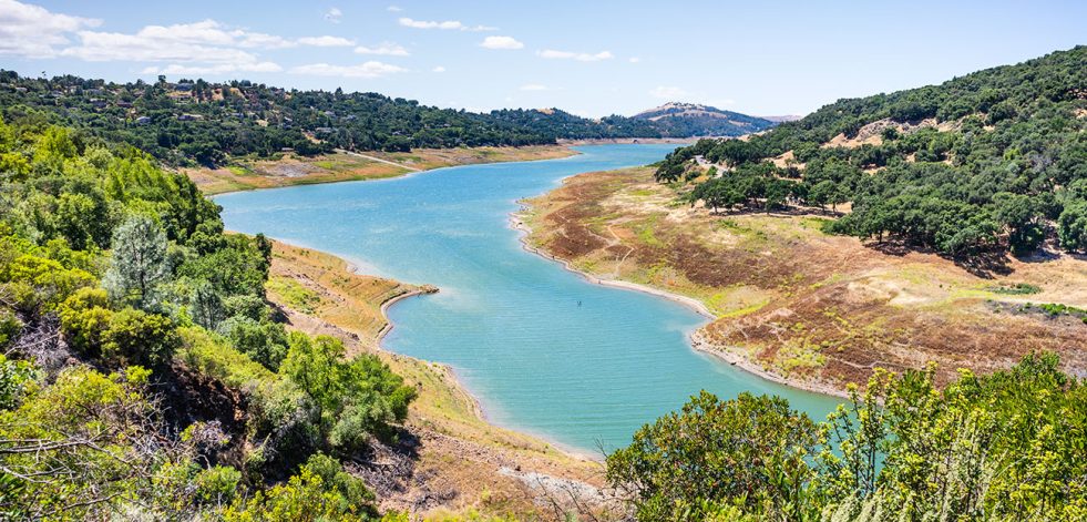High angle view of Anderson Reservoir, a man made lake in Morgan Hill, managed by the Santa Clara Valley Water District, maintained at low level due to failure risk in case of earthquake; California