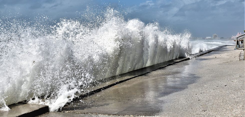 Large wave is crashing into beach wall