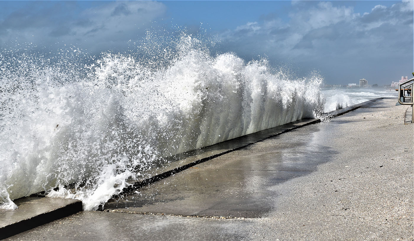 Large wave is crashing into beach wall