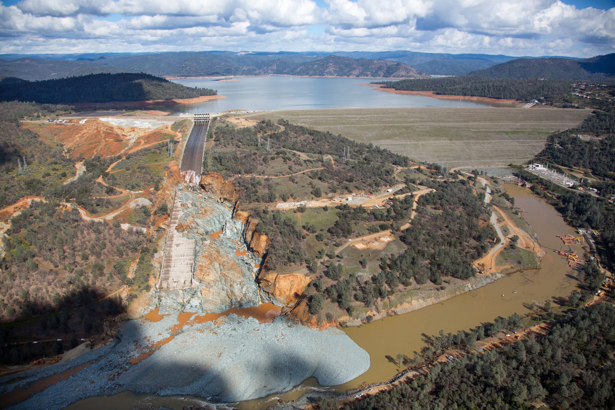 An aerial view of the damaged Oroville Dam spillway site and the huge debris field in the diversion pool just below the spillway.